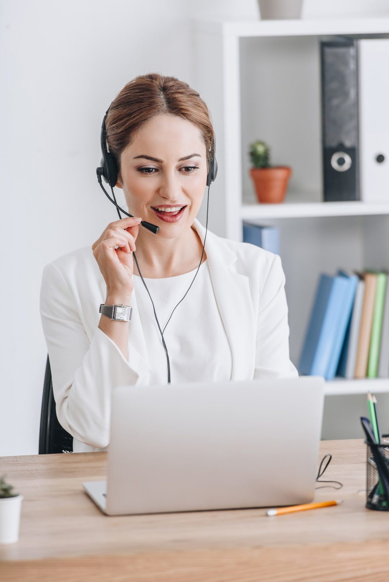 beautiful-female-operator-working-with-headset-and-laptop-in-modern-office-e1639551945790